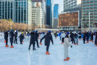 2 Ocak 2023 'te Güney Kore' deki Belediye Binası 'nın önündeki geçici buz pateni pistinde insanlar buz pateni yapıyor.