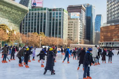 2 Ocak 2023 'te Güney Kore' deki Belediye Binası 'nın önündeki geçici buz pateni pistinde insanlar buz pateni yapıyor.