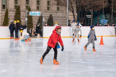 İnsanlar 6 Ocak 2023 'te Güney Kore' deki Belediye Binası 'nın önündeki geçici buz pateni pistinde buz pateni yapıyorlar.