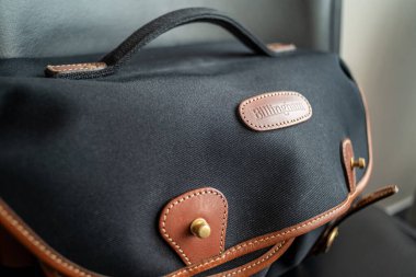 25 Temmuz 2023 tarihinde Güney Kore, Seul 'de siyah Fibrenyte ve bronz derili Billingham Hadley Pro kamera omuz çantası