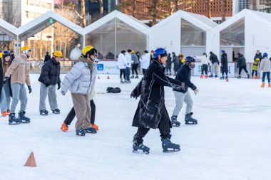 İnsanlar 23 Aralık 2023 'te Güney Kore' deki Belediye Binası 'nın önündeki geçici buz pateni pistinde buz pateni yapıyorlar.