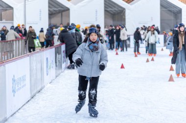 İnsanlar 23 Aralık 2023 'te Güney Kore' deki Belediye Binası 'nın önündeki geçici buz pateni pistinde buz pateni yapıyorlar.