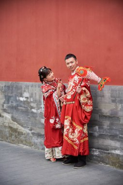 19 Nisan 2024 'te Pekin, Çin' de eski bir Hutong caddesinde poz veren sevimli Çinli düğün çifti.