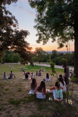 Young people picnic and enjoy sunset view of Prague cityscape in summer in Riegrovy Sady park in the Vinohrady district in Prague, capital of Czech Republic on 22 July 2024 clipart