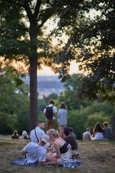 stock image Young people picnic and enjoy sunset view of Prague cityscape in summer in Riegrovy Sady park in the Vinohrady district in Prague, capital of Czech Republic on 22 July 2024