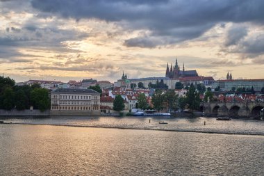 Çek Cumhuriyeti 'nin başkenti Prag' daki Prag kalesi, Vltava nehri ve Mala strana ilçesinin 24 Temmuz 2024 tarihli renkli gün batımı manzarası