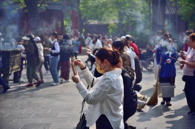 Çin 'in Pekin bölgesindeki Dongcheng bölgesinde 21 Nisan 2024' te Tibet Budizmi Yonghe Tapınağı 'nda insanlar tütsü yakıp dua ediyor.