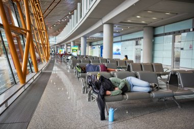23 Nisan 2024 tarihinde Pekin 'in başkenti Pekin' deki BCIA Uluslararası Havalimanı 'nda uçuşlar arasında uyuyan yolcular