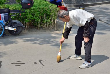 Su kaligrafisi yapan adam (toprak yazma - dishu), 21 Nisan 2024 tarihinde Pekin, Çin 'de emekli Çinliler arasında popüler bir hobi.