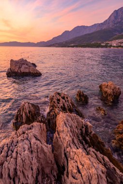 Hırvatistan 'ın Split-Dalmaçya Eyaleti' ndeki Adriyatik Denizi 'nin popüler turistik kıyı şeridi Makarska Riviera' da renkli bir gün batımı