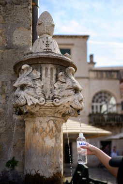 Large Onofrio's Fountain, circular springwater fountain built in 1438 and decorated with ornate, carved-stone masks in Old Town Dubrovnik, Croatia clipart