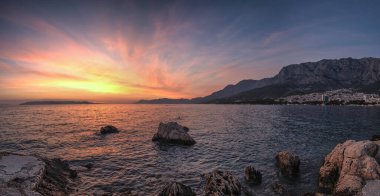 Hırvatistan 'ın Split-Dalmaçya Eyaleti' ndeki Adriyatik Denizi 'nin popüler turistik kıyı şeridi Makarska Riviera' da renkli bir gün batımı