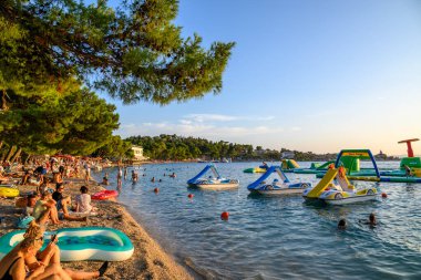 Hırvatistan 'ın Dalmaçya bölgesindeki Adriyatik Denizi' ndeki Makarska Riviera plajında 20 Ağustos 2024 'te güneşlenen insanlar