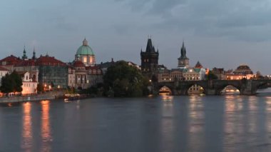 Çek Cumhuriyeti Prag 'daki Vltava nehri ve Prag eski şehir manzarası üzerindeki ikonik Charles Köprüsü' nün hızlandırılmış video akşam görüntüsü