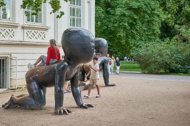 Kampa Park Müzesi 'nde Bebekler' i ziyaret eden turistler, 17 Temmuz 2024 'te Çek ressam David Cerny' nin mutant yüzlü emekleyen bebeklerin bronz heykellerini Prag, Çek Cumhuriyeti 'nde sergilediler.