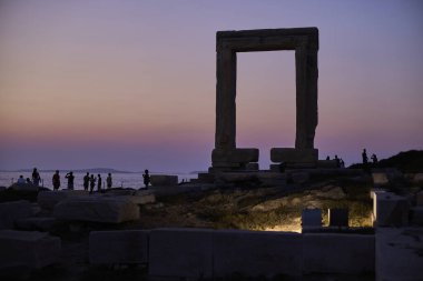 Apollo Tapınağı 'nın portara kapısı 21 Ağustos 2023' te Yunanistan 'ın Ege Denizi' ndeki Naxos adasında günbatımı gökyüzüne karşı siluet oluşturdu.