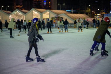 İnsanlar 9 Şubat 2024 'te Güney Kore' nin Seul kentindeki belediye binasının önündeki geçici buz pateni pistinde gece yarısı buz pateni yapıyorlar.
