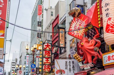 Osaka 'nın Dotonbori bölgesinde restoran işletme tabelaları. Ahtapot yerel lezzeti sembolize eder. 15 Şubat 2024 'te Japonya' nın Osaka kentinde ahtapotla dolu buğday unundan yapılmış top şeklinde bir aperatif olan takoyaki.