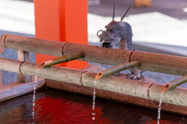 Japonya 'nın Wakayama bölgesinde Nachisan' daki Kumano Nachi Taisha Grand Shinto türbesinin girişinde ellerini yıkamak için ejderha şekilli su musluğu.