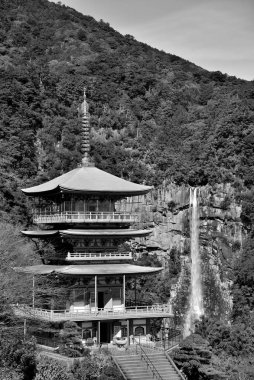 Three story pagoda of Seiganto-ji Tendai Buddhist temple in Wakayama Prefecture, Japan with Nachi Falls in the background clipart