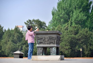 Woman praying on the altair of the Temple of Earth (Ditan Temple), built in 1530 during the Ming dynasty in Beijing, China on 21 April 2024 clipart