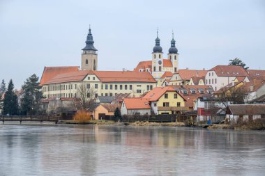 View of Historic old town of Telc, Unesco World Heritage Site, across the frozen Ulicky rybnik pond in winter, in Telc, Czech Republic on 8 February 2025 clipart