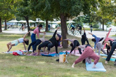 7 Ekim 2023 'te Kore' nin başkenti Seul 'deki Hangang Han nehir parkında yoga yapan bir grup genç.