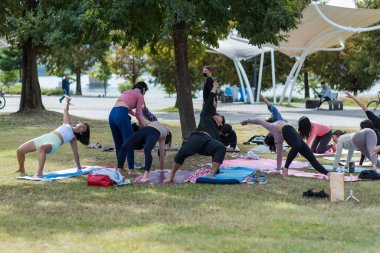 7 Ekim 2023 'te Kore' nin başkenti Seul 'deki Hangang Han nehir parkında yoga yapan bir grup genç.