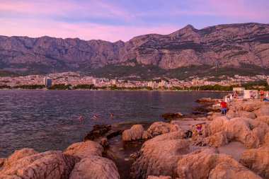 Günbatımında Makarska kasabası, 24 Ağustos 2024 'te Hırvatistan' ın Adriyatik kıyı şeridinde popüler turistik sahil tatil beldesi