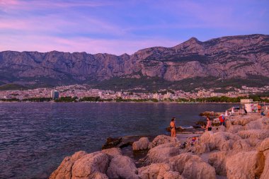 Günbatımında Makarska kasabası, 24 Ağustos 2024 'te Hırvatistan' ın Adriyatik kıyı şeridinde popüler turistik sahil tatil beldesi