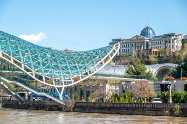1 Nisan 2025 'te Gürcistan' ın başkenti Tiflis 'teki Kura Mtkvari nehri üzerinde barış köprüsü, çelik ve cam bina yaya köprüsü