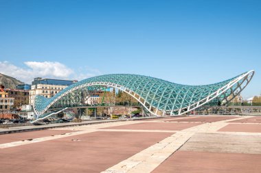 1 Nisan 2025 'te Gürcistan' ın başkenti Tiflis 'teki Kura Mtkvari nehri üzerinde barış köprüsü, çelik ve cam bina yaya köprüsü