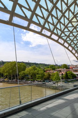 23 Nisan 2025 'te Gürcistan' ın başkenti Tiflis 'teki Kura Mtkvari nehri üzerinde barış köprüsü, çelik ve cam bina yaya köprüsü