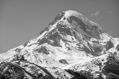 Gergeti Trinity Kilisesi ve Kazbek Dağı, Gürcistan 'ın Kafkasya dağlarındaki popüler turizm beldesi Stepantsminda köyü yakınlarında.