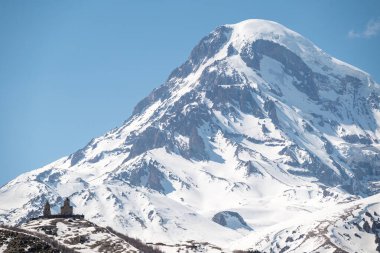 Gergeti Trinity Kilisesi ve Kazbek Dağı, Gürcistan 'ın Kafkasya dağlarındaki popüler turizm beldesi Stepantsminda köyü yakınlarında.