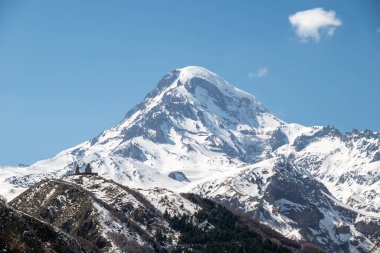 Gergeti Trinity Kilisesi ve Kazbek Dağı, Gürcistan 'ın Kafkasya dağlarındaki popüler turizm beldesi Stepantsminda köyü yakınlarında.