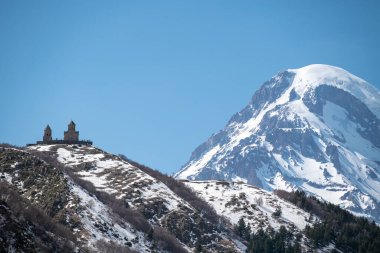 Gergeti Trinity Kilisesi ve Kazbek Dağı, Gürcistan 'ın Kafkasya dağlarındaki popüler turizm beldesi Stepantsminda köyü yakınlarında.