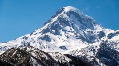 Gergeti Trinity Kilisesi ve Kazbek Dağı, Gürcistan 'ın Kafkasya dağlarındaki popüler turizm beldesi Stepantsminda köyü yakınlarında.