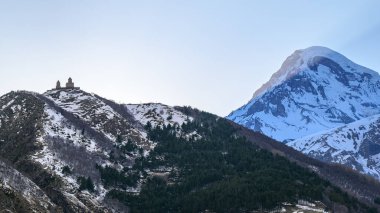 Gergeti Trinity Kilisesi ve Kazbek Dağı, Gürcistan 'ın Kafkasya dağlarındaki popüler turizm beldesi Stepantsminda köyü yakınlarında.