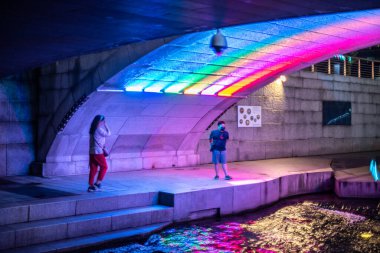 10 Ekim 2021 'de Güney Kore' nin başkenti Seul 'deki halk parkında Cheonggyecheon Stream' de dinlenen insanlar