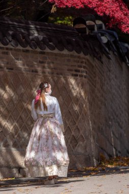 Geleneksel Koreli Hanbok elbiseli turist 7 Kasım 2021 'de Güney Kore' nin Seul kentinde, Joseon hanedanlığının Changdeokgung kraliyet sarayını ziyaret ediyor.