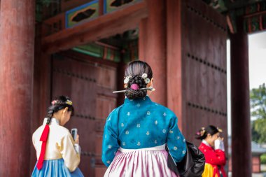 Geleneksel Koreli Hanbok elbiseli turistler 23 Ekim 2022 tarihinde Güney Kore 'nin başkenti Seul' deki Joseon hanedanlığının Changdeokgung kraliyet sarayını ziyaret ettiler.