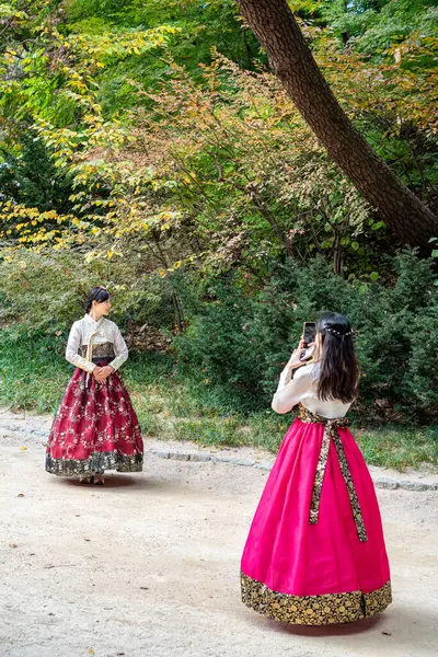 Geleneksel Koreli Hanbok elbiseli turistler 23 Ekim 2022 tarihinde Güney Kore 'nin başkenti Seul' deki Joseon hanedanlığının Changdeokgung kraliyet sarayını ziyaret ettiler.