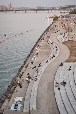28 Mayıs 2022 'de Güney Kore' nin başkenti Seul 'de Han Nehri' ndeki Yeouido Parkı 'nda piknik yapan insanlar görülüyor.