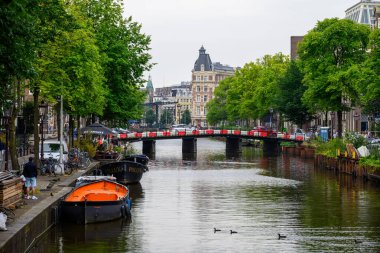 Hollanda 'nın başkenti Amsterdam' da 20 Temmuz 2025 'te ikonik tekne kanalları ve renkli cepheleriyle tarihi Amsterdam kasabası