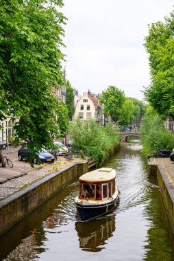 Hollanda 'nın başkenti Amsterdam' da 20 Temmuz 2025 'te ikonik tekne kanalları ve renkli cepheleriyle tarihi Amsterdam kasabası