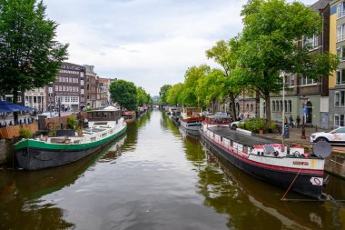 Hollanda 'nın başkenti Amsterdam' da 20 Temmuz 2025 'te ikonik tekne kanalları ve renkli cepheleriyle tarihi Amsterdam kasabası