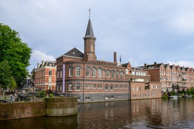 Hollanda 'nın başkenti Amsterdam' da 20 Temmuz 2025 'te ikonik tekne kanalları ve renkli cepheleriyle tarihi Amsterdam kasabası