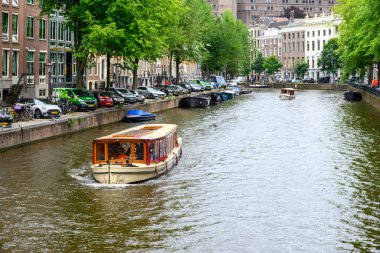 Hollanda 'nın başkenti Amsterdam' da 21 Temmuz 2025 'te ikonik tekne kanalları ve renkli cepheleriyle tarihi Amsterdam kasabası