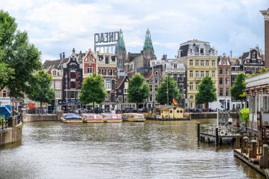 Hollanda 'nın başkenti Amsterdam' da 21 Temmuz 2025 'te ikonik tekne kanalları ve renkli cepheleriyle tarihi Amsterdam kasabası
